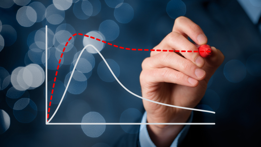 A hand in a suit draws a red dashed upward curve on a transparent virtual graph, overlaying a white curve against a blurred blue background with circular bokeh lights.