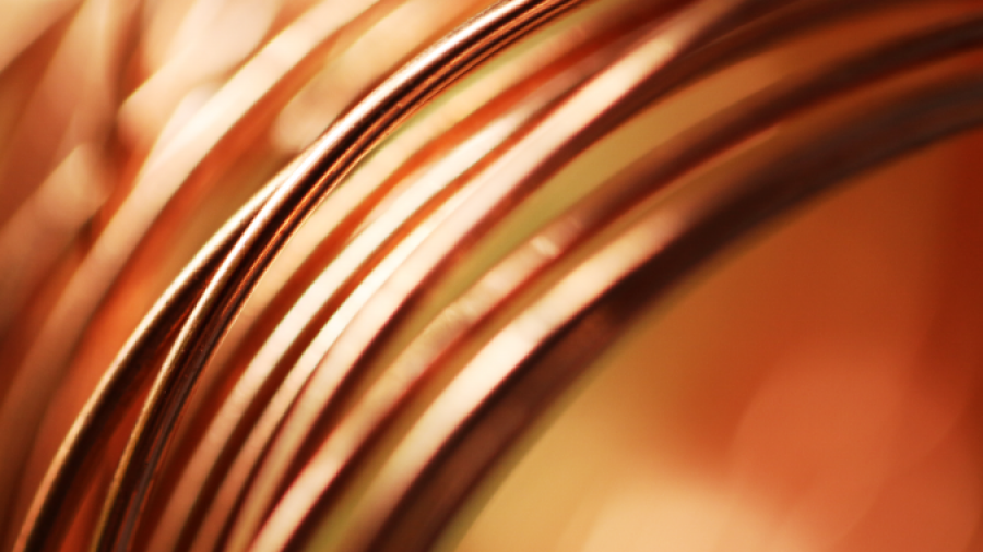 Close-up of several copper wires elegantly coiled together, with a warm, out-of-focus copper-toned background that emphasizes the metallic sheen and curved lines of the wires.