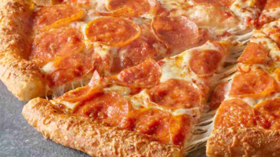 A close-up of a pepperoni pizza with a golden, cheese-stuffed crust. One slice is being pulled away, showing melted cheese stretching from the pizza. The pizza sits on a gray, textured surface.