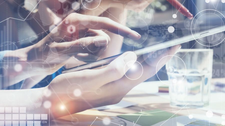 Two people use digital tablets and smartphones at a table with documents and a glass of water, overlaid with digital data icons, graphs, and scientific symbols representing technology and data analysis.