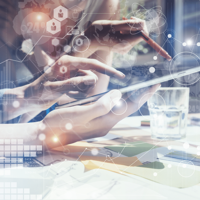 Two people use digital tablets and smartphones at a table with documents and a glass of water, overlaid with digital data icons, graphs, and scientific symbols representing technology and data analysis.