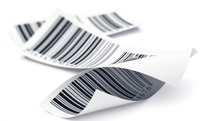 A close-up of several curled paper labels with printed barcodes, lying overlapping on a white background.