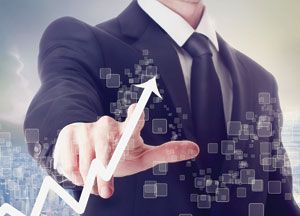 A man in a business suit touches a virtual screen displaying a rising white arrow, symbolizing growth or success in supply chain cost management, with digital squares in the background.