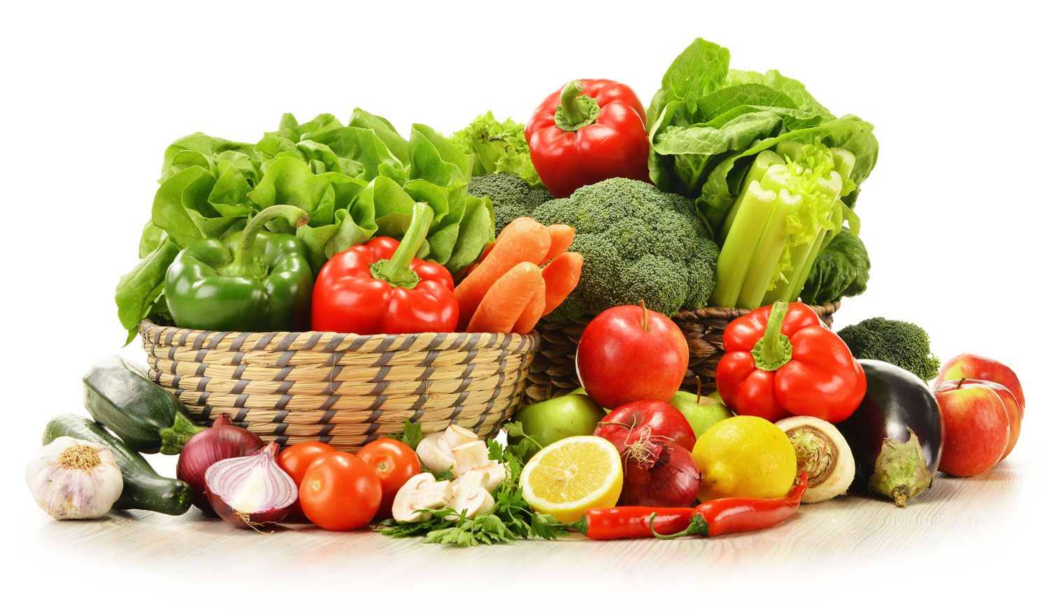 A colorful assortment of fresh vegetables and fruits, including lettuce, bell peppers, carrots, broccoli, tomatoes, lemons, onions, eggplant, garlic, chilies, and apples, arranged on a white background.