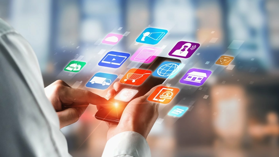 A person uses a smartphone with colorful, floating app icons—shopping, communication, media, and retail OMS—appearing above the device, symbolizing mobile technology and digital connectivity.