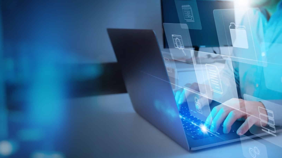 A person types on a laptop with floating digital icons, such as folders and documents, representing cloud computing and data management concepts in a modern, technology-filled environment.