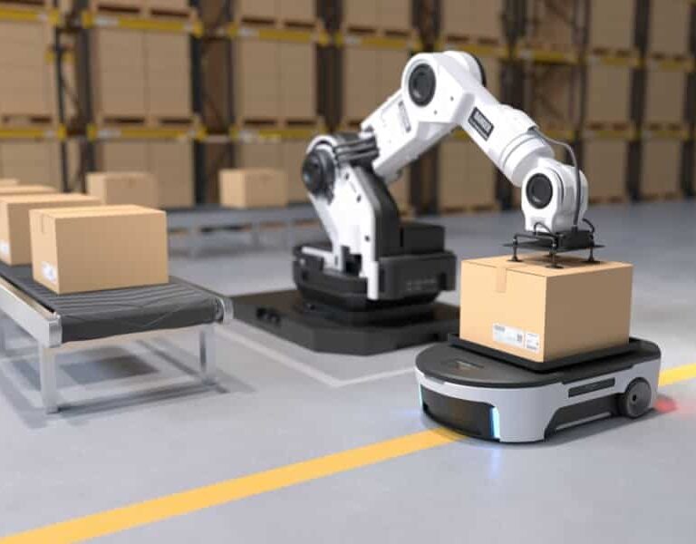 A robotic arm places a cardboard box onto an autonomous mobile robot in a warehouse, showcasing the future of supply chain; more boxes are lined up on a conveyor belt and shelves filled with boxes are in the background.