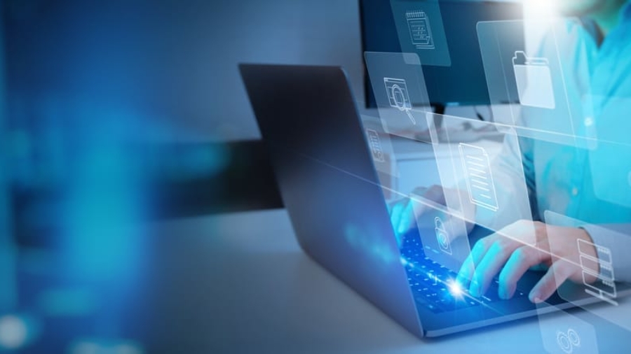 A person types on a laptop surrounded by floating digital icons—folders, documents, and a clock—symbolizing cloud computing, online data storage, and digital workflow in the context of business central vs finance and supply chain management.