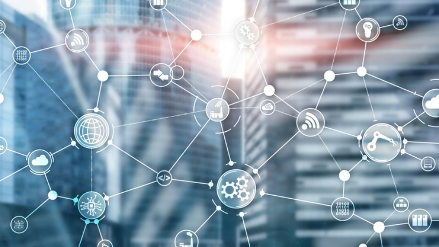 Network of interconnected digital icons representing various technologies and industries, overlaid on a blurred modern glass office building background, symbolizing connectivity, planning strategy, and smart city concepts.
