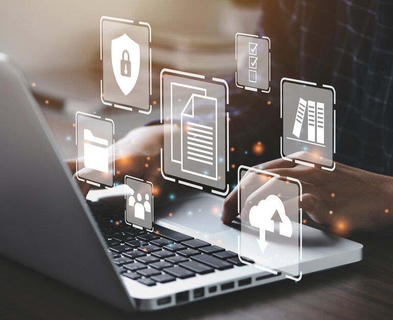 A person types on a laptop with digital icons floating above the keyboard, including symbols for security, Microsoft application management, cloud storage, folders, and documents, representing online data management and cybersecurity.