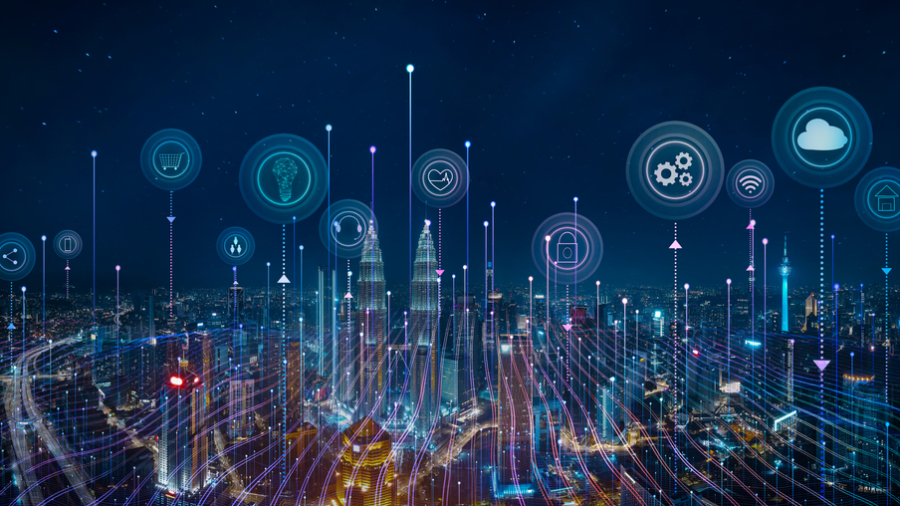 A city skyline at night with digital icons above buildings, representing cloud computing, data, security, and smart technology, connected by glowing lines to illustrate a smart city network.