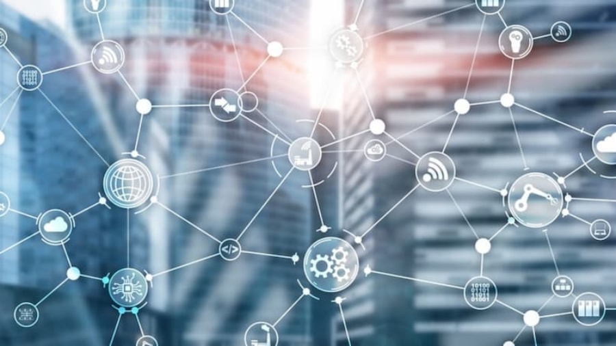 A transparent network of interconnected digital icons, including AMR and gears, overlays a blurred cityscape with modern glass buildings, visually representing what is supply chain strategy in a high-tech urban context.