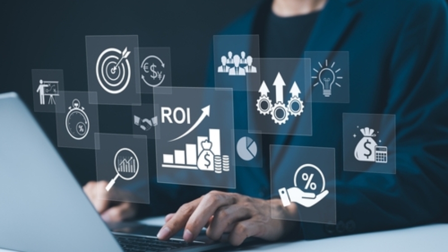 A person in a suit types on a laptop with floating digital icons, including graphs, a target, gears, and symbols representing ROI and financial growth—conveying the efficiency of a Transportation Management System.