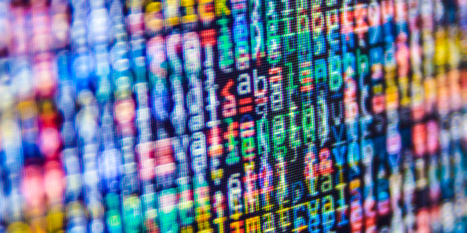A close-up of a computer screen displaying colorful, blurred lines of code in various programming languages, with characters and symbols in shades of blue, red, green, and yellow.