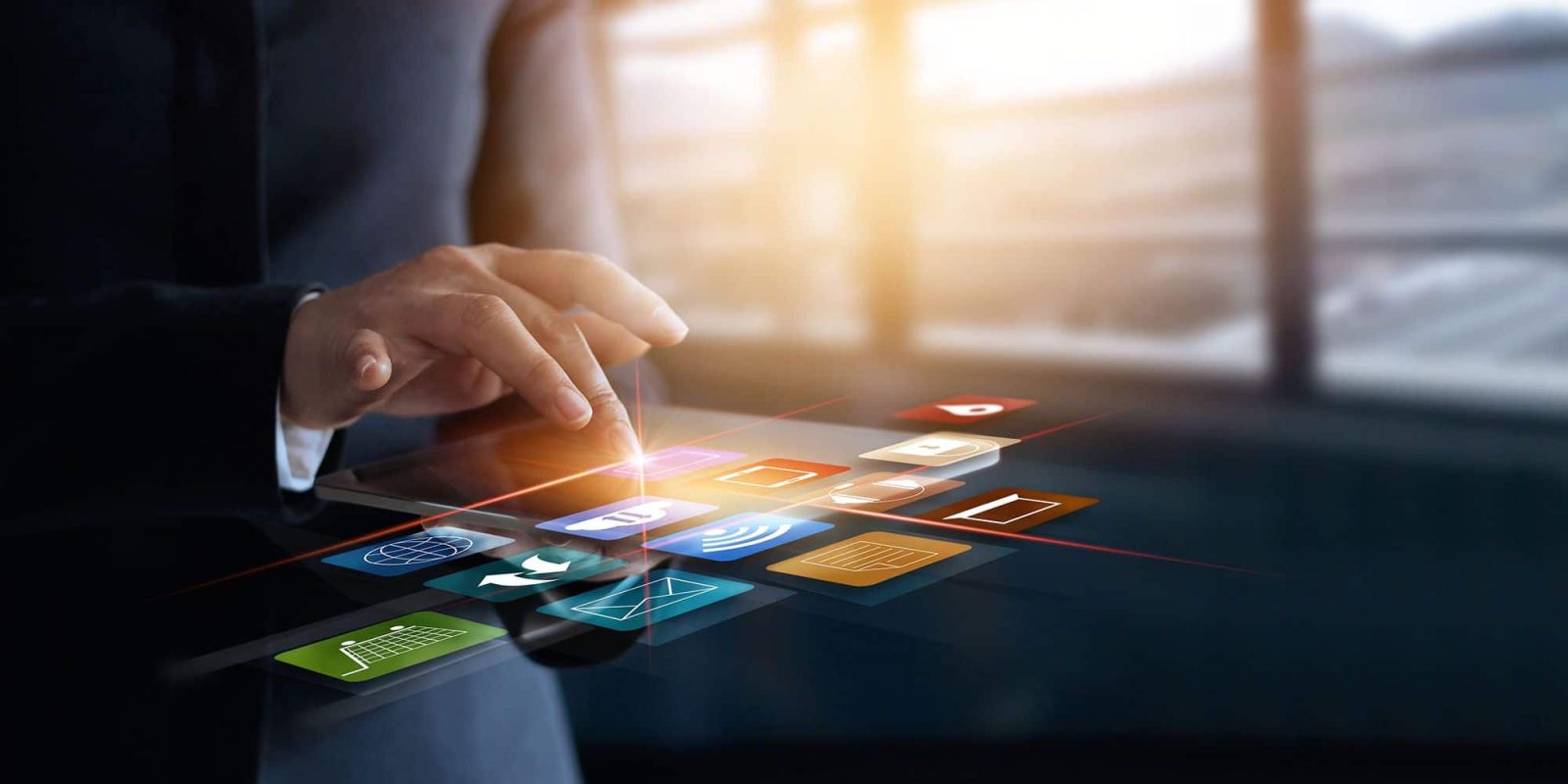 A person in a suit interacts with colorful floating digital icons, representing various apps and technologies like what is omnichannel fulfilment, against a blurred office background with large windows.