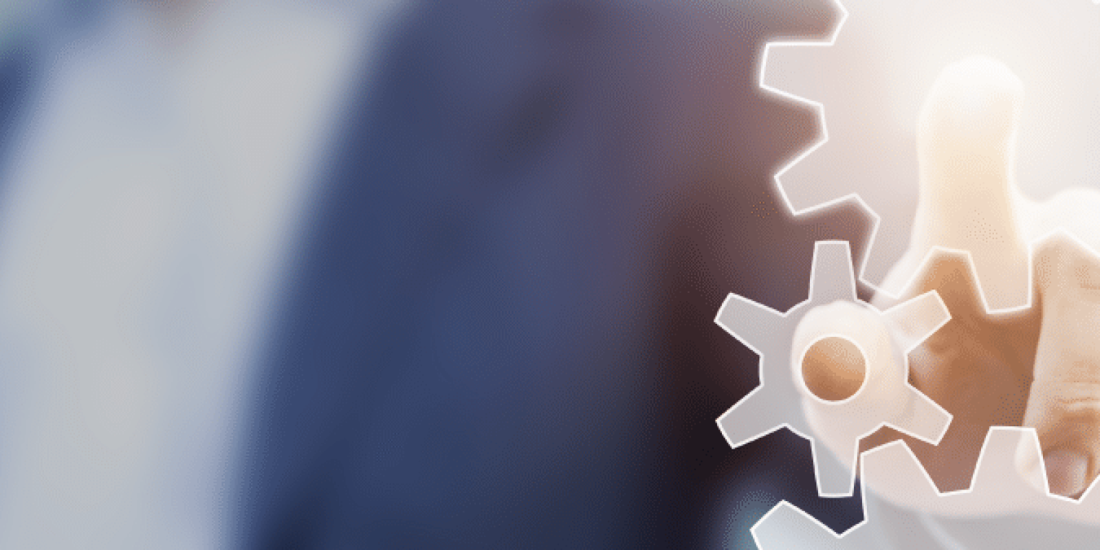 A person in a business suit is pressing a glowing gear icon on a transparent virtual touchscreen, symbolizing technology, Lean Process Improvements, or innovation. The blurred background emphasizes the focus on efficient process management.