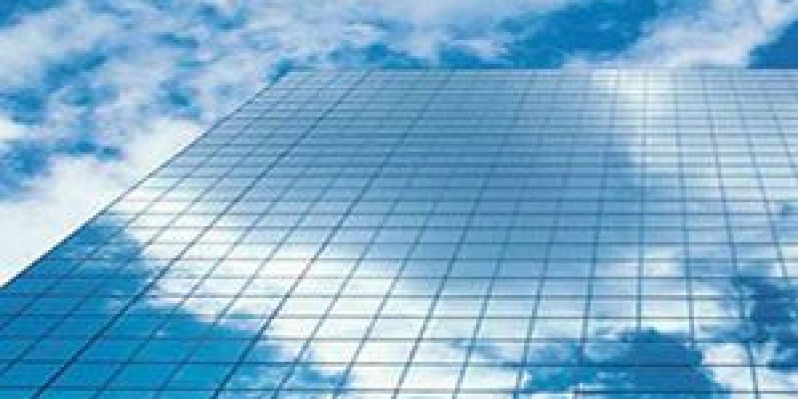 A tall glass building reflects a blue sky with white clouds, creating an almost seamless blend between the architecture and the sky above.
