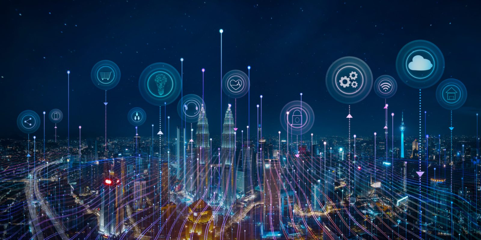 A city skyline at night with digital icons above buildings, representing cloud computing, data, security, and smart technology, connected by glowing lines to illustrate a smart city network.