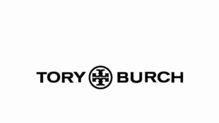 The image displays the Tory Burch logo with the brand name Tory Burch in bold black letters, separated by a circular geometric emblem in the center on a white background.