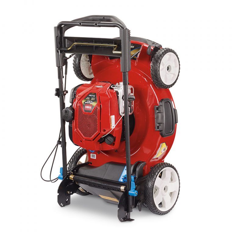 A red and black lawn mower is shown standing upright on its rear wheels, with the handle folded for compact storage—a smart choice inspired by efficient supply chain network design & optimization services. The mower’s underside and cutting blade are visible.