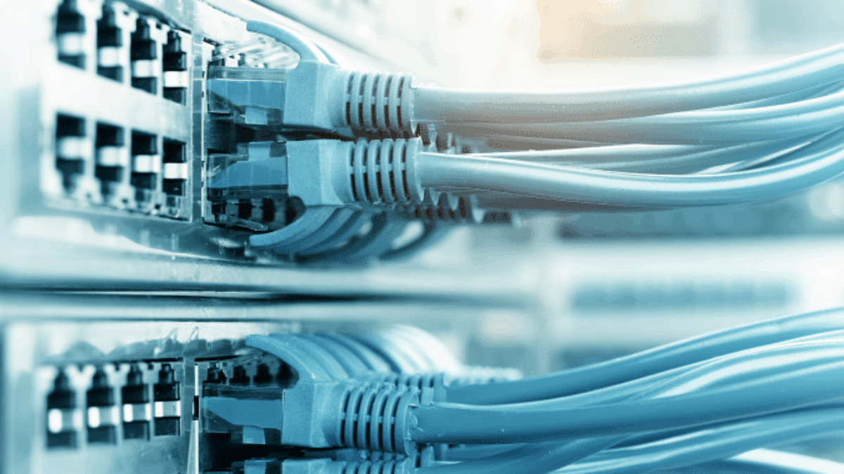 Close-up of several network switches with multiple blue Ethernet cables plugged into the ports, indicating active data connections in a server or data center environment.