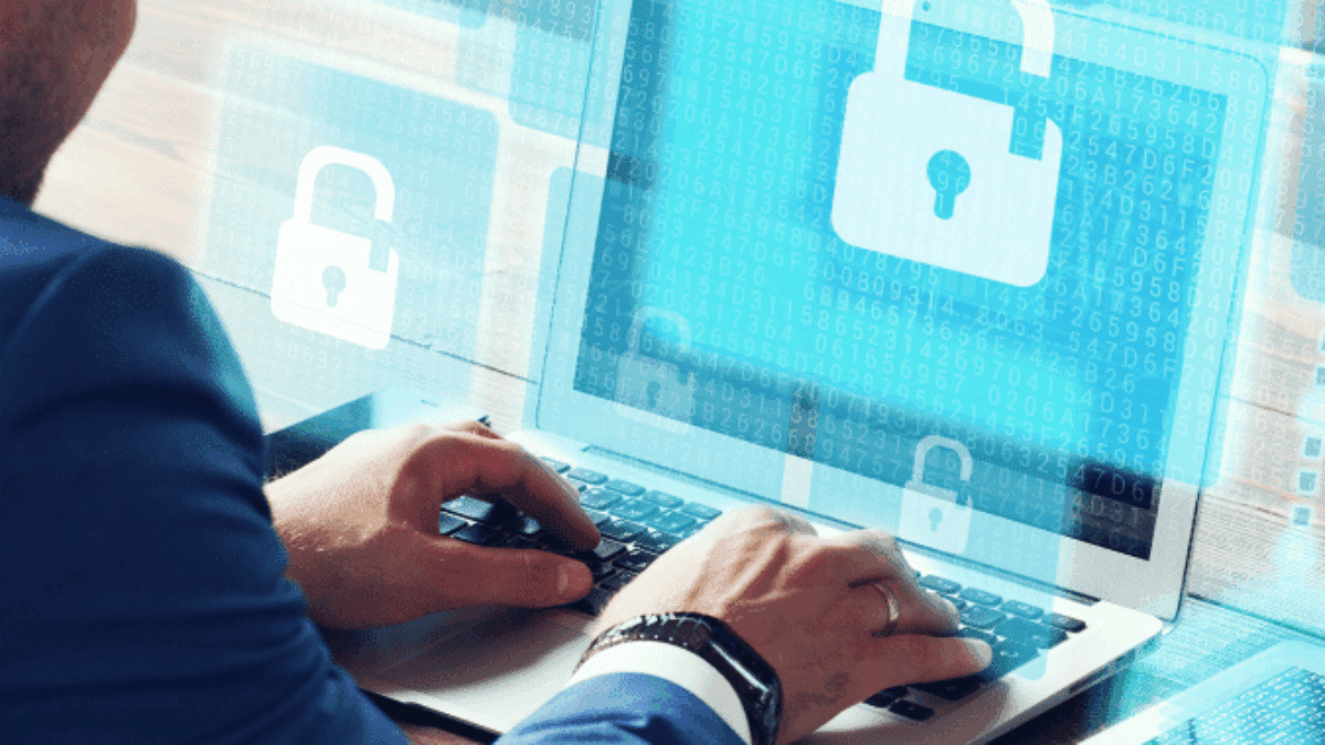 A person in a blue suit uses a laptop displaying digital padlock icons, symbolizing cybersecurity, data protection, and secure IT managed services. Transparent padlock graphics appear around the screen, emphasizing protected access.