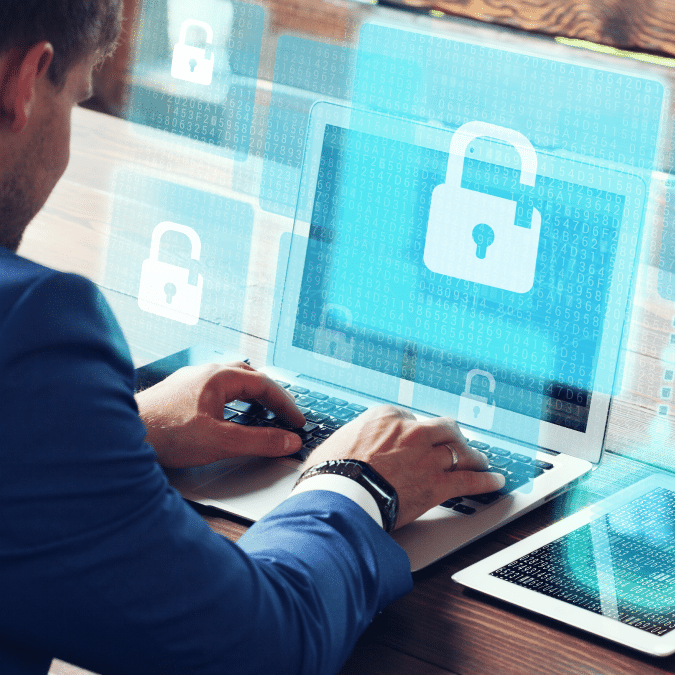 A person in a blue suit uses a laptop displaying digital padlock icons, symbolizing cybersecurity, data protection, and secure IT managed services. Transparent padlock graphics appear around the screen, emphasizing protected access.