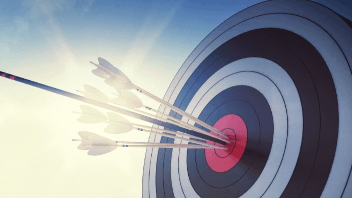 A close-up of a target with several arrows clustered in the bullseye, illuminated by sunlight against a blue sky, symbolizing accuracy and precision.