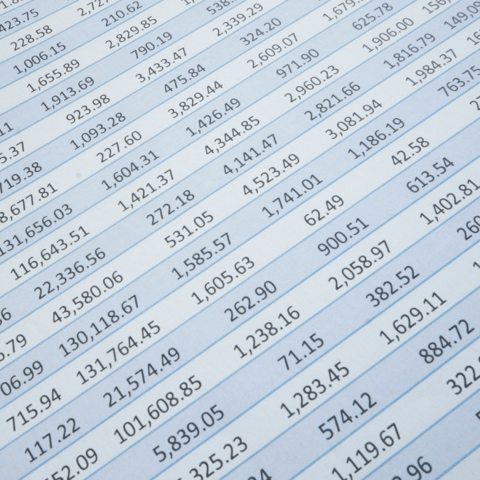 A close-up view of rows and columns of numerical data printed on paper, resembling a financial or accounting spreadsheet with various currency amounts.