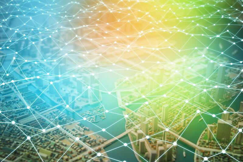 A digital illustration of a city landscape overlaid with a glowing network of interconnected lines and dots, symbolizing connectivity or smart city technology in the retail supply chain, set against a gradient blue to yellow background.
