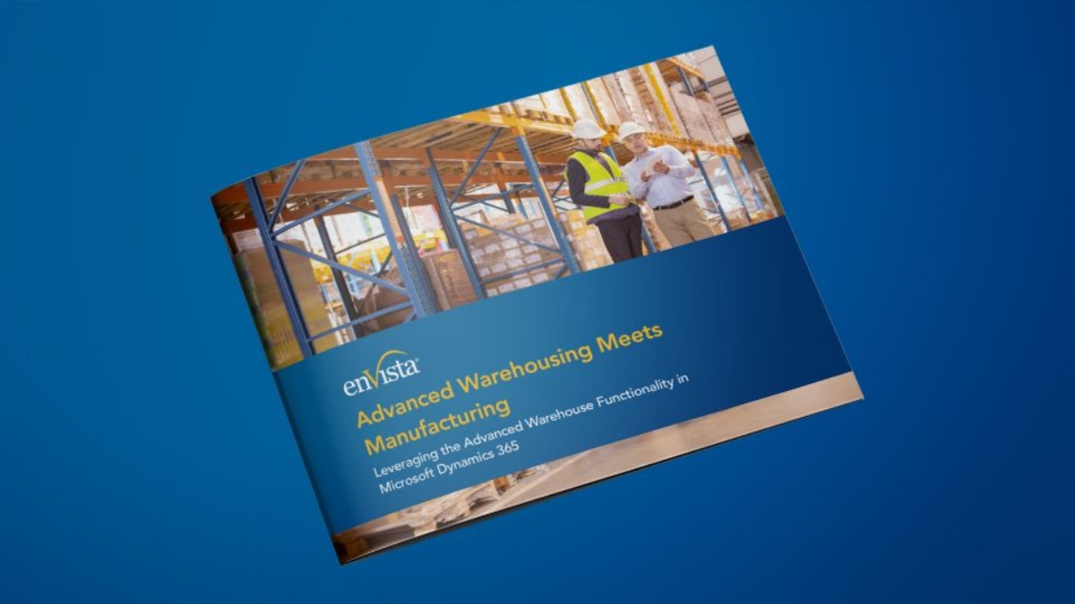 A brochure on a blue surface displays the enVista logo and the title Advanced Warehousing Meets Manufacturing with a photo of two construction workers in safety gear reviewing plans at a building site.