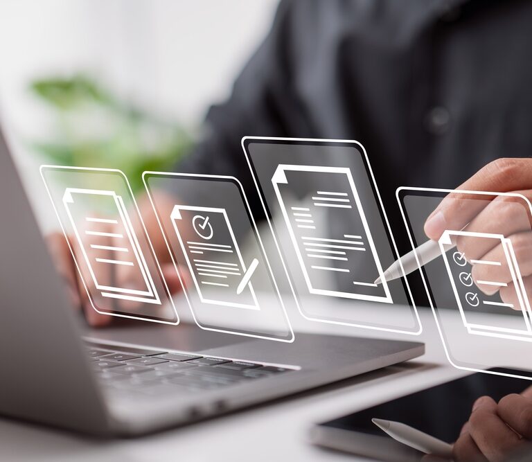 A person using a stylus writes on a digital tablet in front of a laptop, with transparent icons of documents, checklists, and signatures floating in the foreground, symbolizing digital document management.