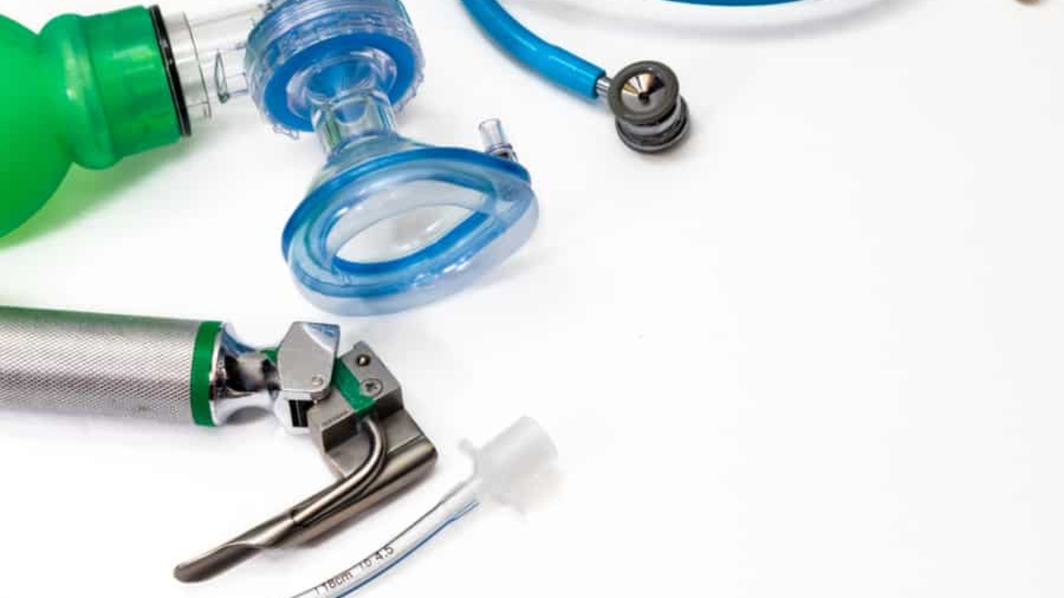 A close-up of medical equipment, including a green manual resuscitator, blue oxygen mask, laryngoscope, endotracheal tube, and stethoscope on a white background—ideal for illustrating a WMS Implementation Case Study in healthcare settings.