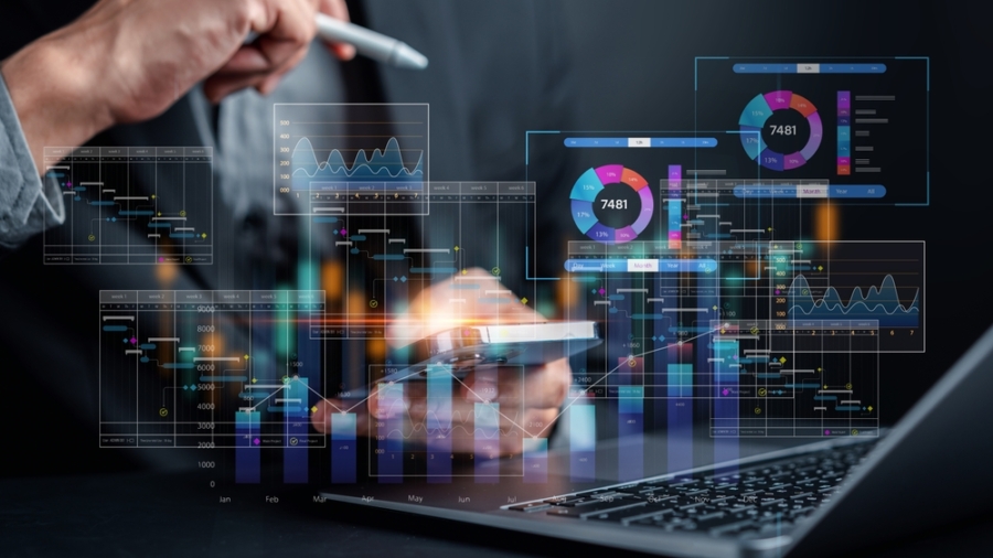A person using a smartphone and laptop, surrounded by virtual financial charts, graphs, and data visualizations, representing digital financial analysis and investment in a modern, technology-driven environment.