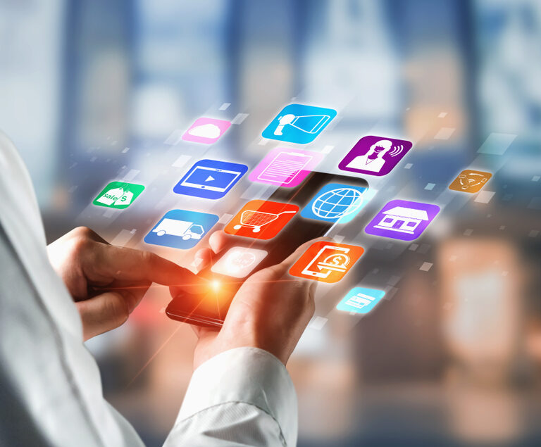 A person uses a smartphone with colorful app icons, including artificial intelligence services, floating above the screen, symbolizing various digital and online services. The blurred background highlights the focus on mobile technology.