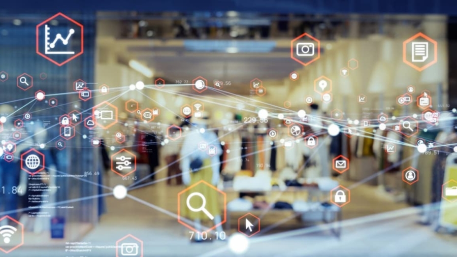 A blurred view of a clothing store interior is overlaid with digital icons and data graphics, symbolizing retail technology, data analysis, and digital connectivity in the modern shopping experience.