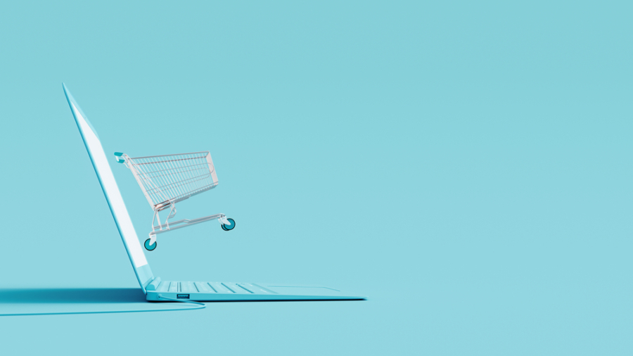 A shopping cart emerges from the screen of an open laptop on a light blue background, symbolizing online shopping and highlighting 2025 Retail Fulfillment Trends.