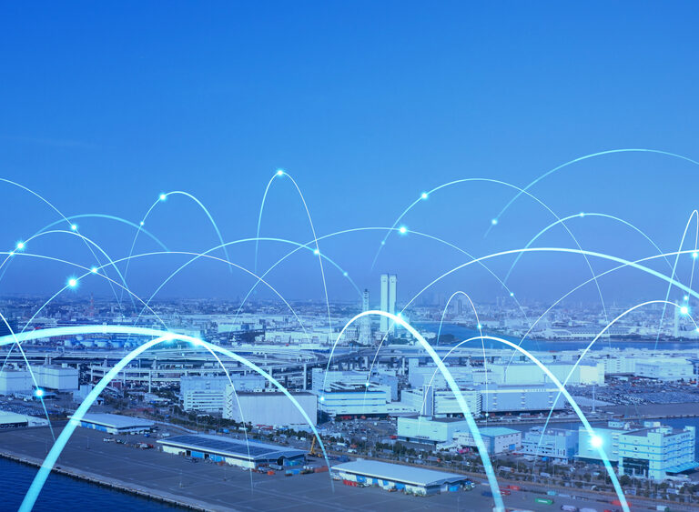 A city skyline and port with digital blue arcs overlaying the image, symbolizing data connectivity and communication networks that drive retail growth and shape what is supply chain strategy across the urban landscape.