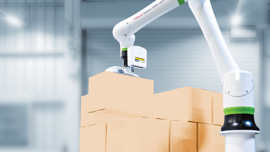 A robotic arm is stacking cardboard boxes in a warehouse with a bright, industrial interior. The background shows metal structures and large doors.