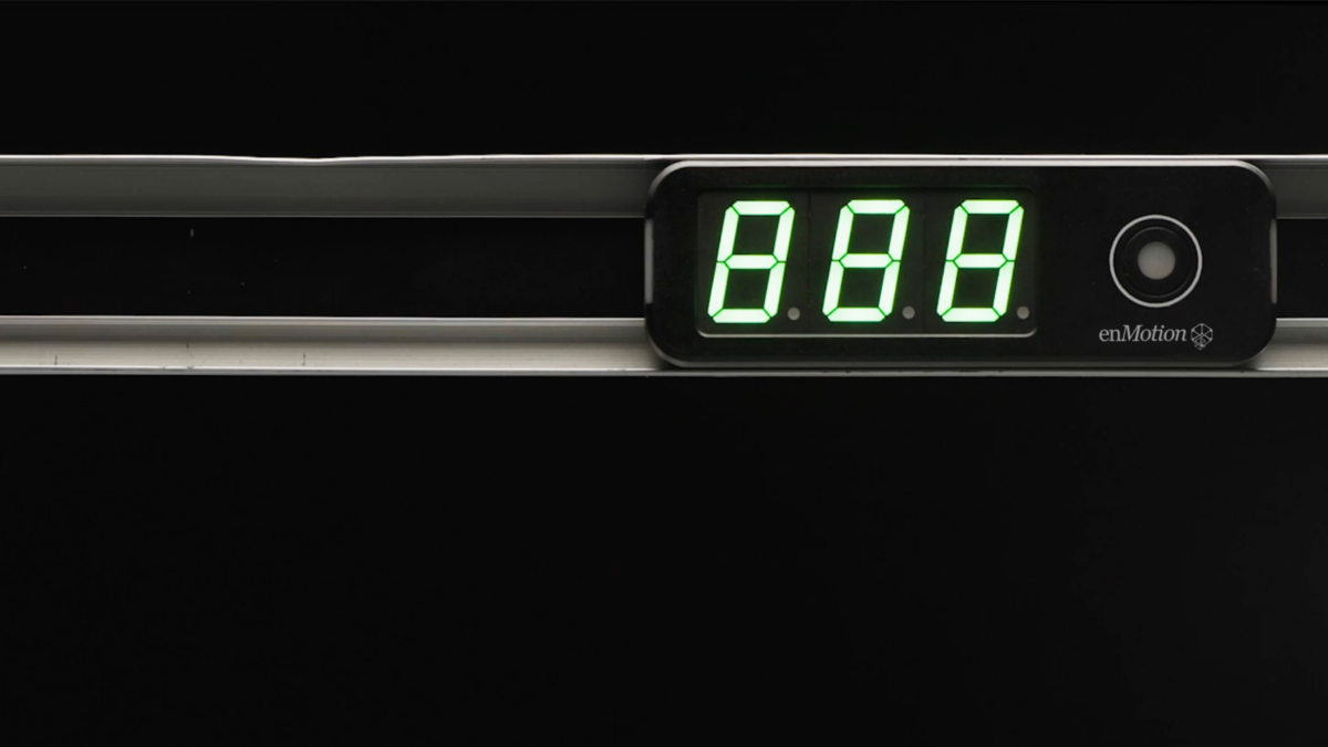 A close-up of a digital display showing the numbers 888 in green against a black background, with a circular button to the right and the enMotion logo below—a design offering a warehouse advantage in efficiency and control.