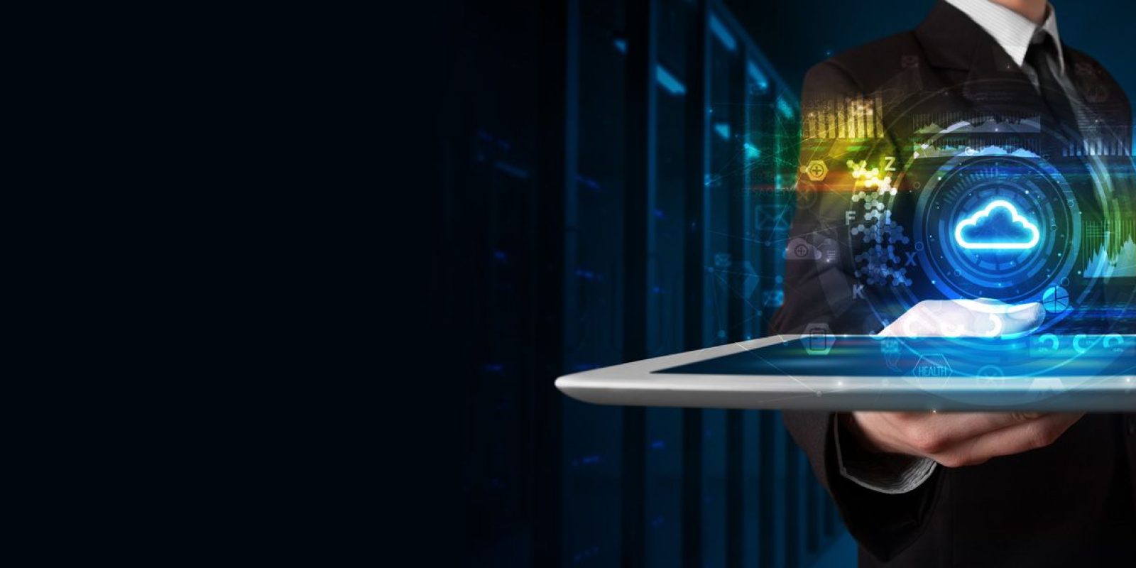 A person in a suit holding a tablet with a glowing cloud computing icon and digital data graphics hovering above it, symbolizing cloud technology and data management, with a dark server room background.