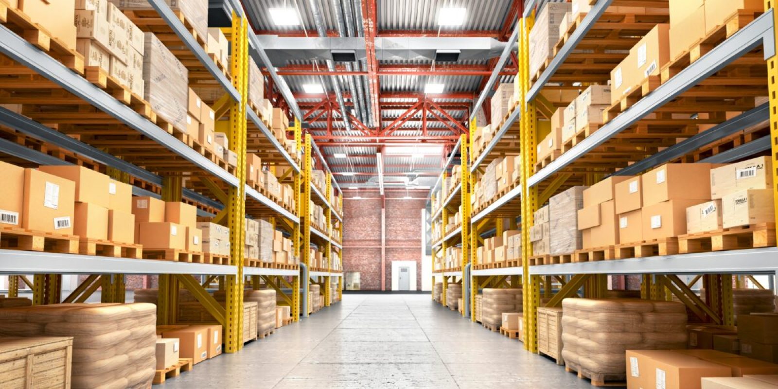 A spacious warehouse with tall shelves filled with cardboard boxes and packages. Robotics integration streamlines operations, while organized rows and a clear concrete floor create an orderly environment brightly illuminated throughout.