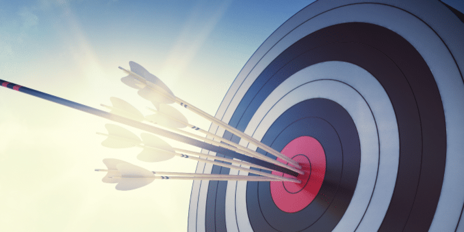 A close-up of a target with several arrows clustered in the bullseye, illuminated by sunlight against a blue sky, symbolizing accuracy and precision.