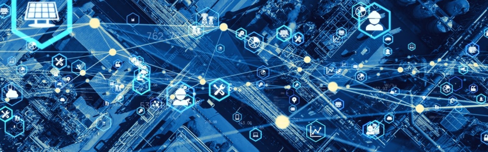 Aerial view of an industrial facility overlaid with digital icons and network lines, symbolizing data connectivity, supply chain optimization, smart technology, and industrial automation. The color scheme is predominantly blue.