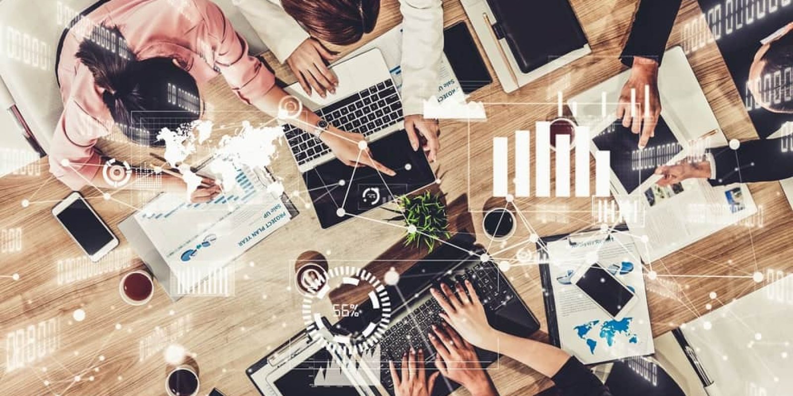 A group of people work together at a table with laptops, tablets, documents, and coffee. Digital graphics overlay the scene, showing charts and data visualizations as they collaborate to select the right ERP system for their business needs.