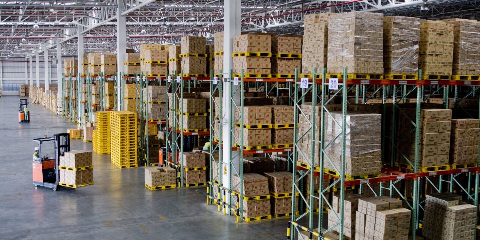 A warehouse with boxes on shelves, efficiently organized by staff working under an incentive based pay system.